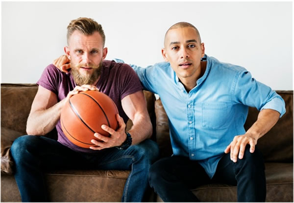 Man sitting together on a couch watching sport