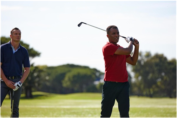 Friends with golf swing for driver training on grass